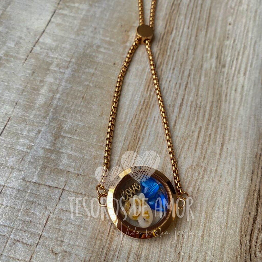 Brazalete relicario redondo dorado liso con figura pie con lámina decorativa dorada, figura corazón azul con pelo de perro y pieza metálica dorada “love”