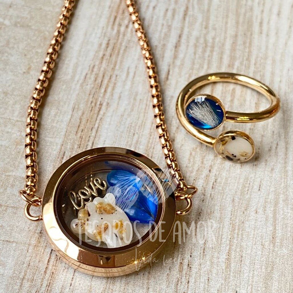 Brazalete relicario redondo dorado liso con figura pie con lámina decorativa dorada, figura corazón azul con pelo de perro y pieza metálica dorada “love”; anillo doble con pelo de perro y lámina decorativa dorada