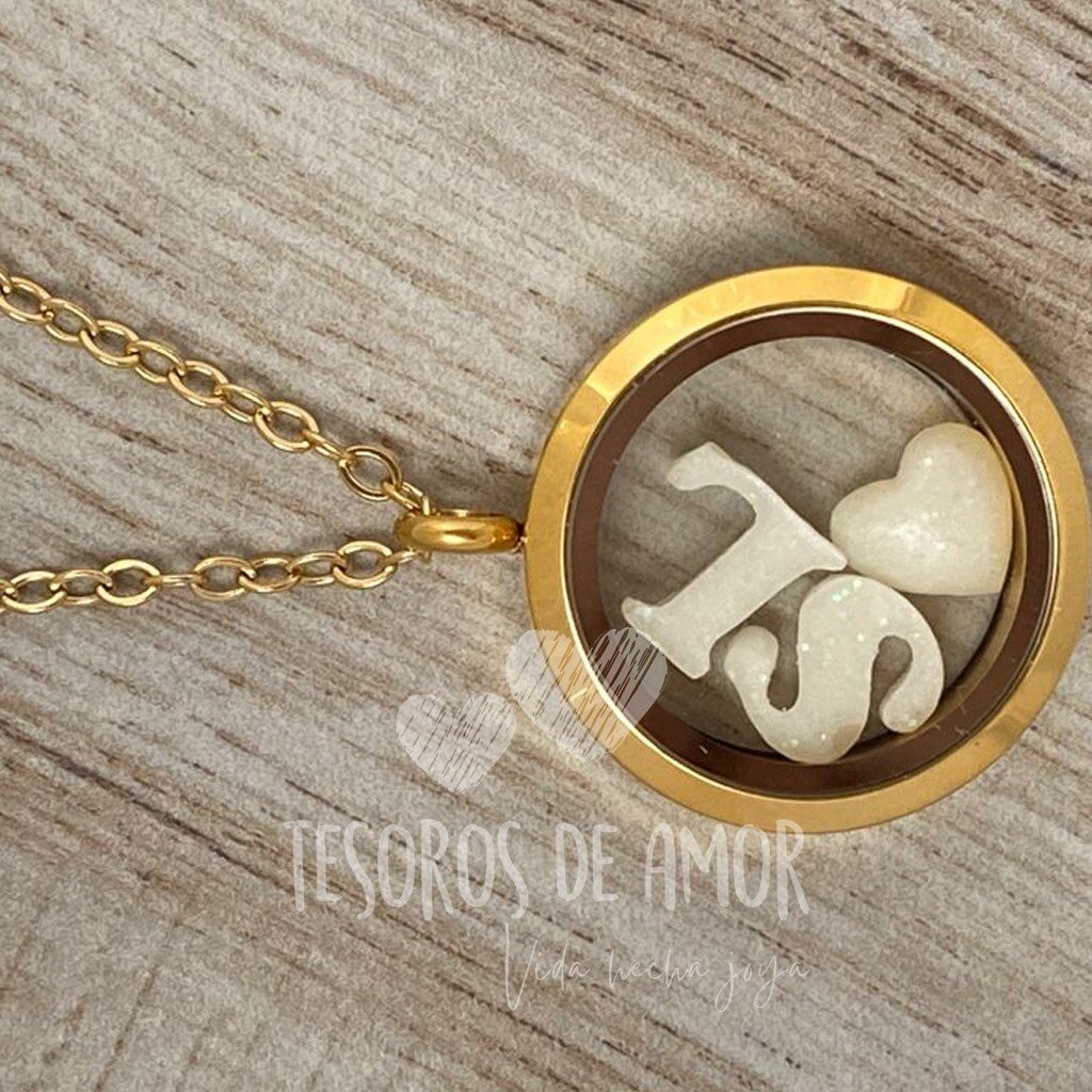 Relicario dorado con figuras letra “S”, “L” y corazón con glitter blanco