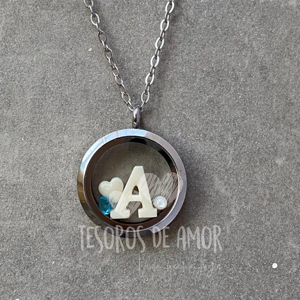 Relicario redondo liso con figuras “corazón” y letra “A” con dos piedras del mes